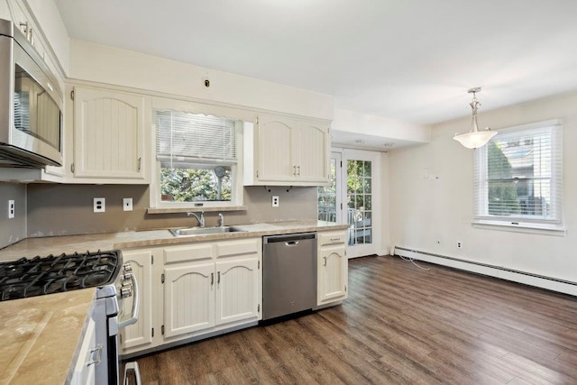 kitchen featuring dark wood finished floors, a sink, light countertops, appliances with stainless steel finishes, and a wealth of natural light