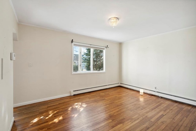 empty room with hardwood / wood-style flooring, crown molding, baseboards, and baseboard heating