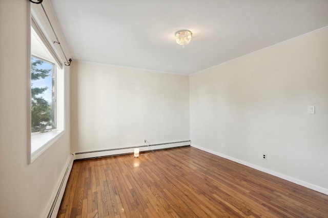 unfurnished room featuring baseboard heating, ornamental molding, baseboards, and hardwood / wood-style floors