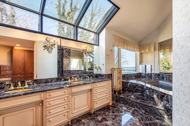 bathroom with a sink, a chandelier, a bath, marble finish floor, and double vanity