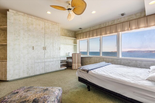 bedroom with recessed lighting, a water view, carpet floors, visible vents, and a ceiling fan