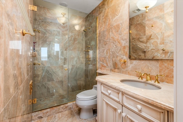bathroom featuring vanity, tile walls, toilet, a stall shower, and visible vents