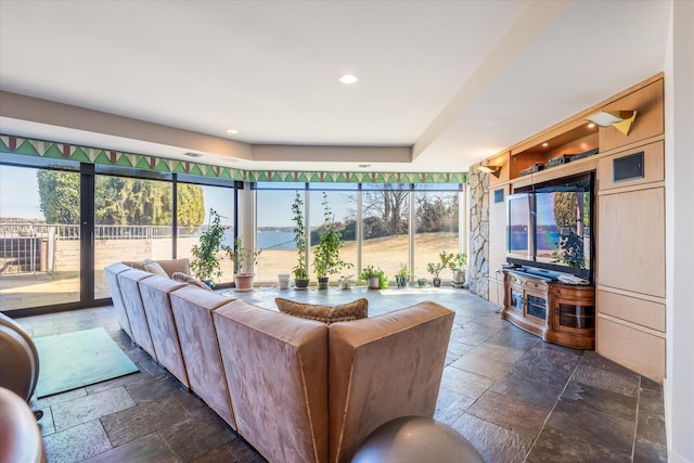 living room featuring stone tile flooring and recessed lighting