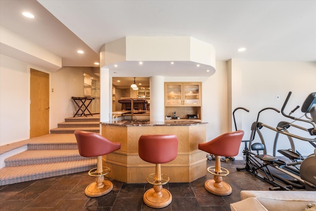 bar featuring stone finish floor, bar area, and recessed lighting