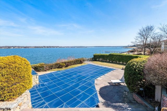 view of swimming pool with a water view and a patio