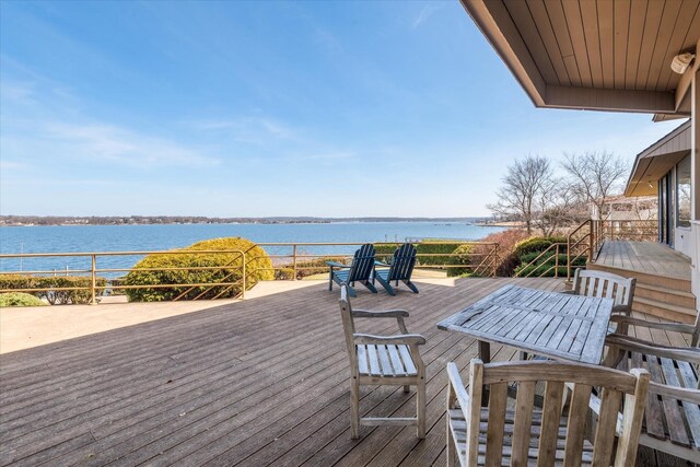 deck featuring a water view and outdoor dining area