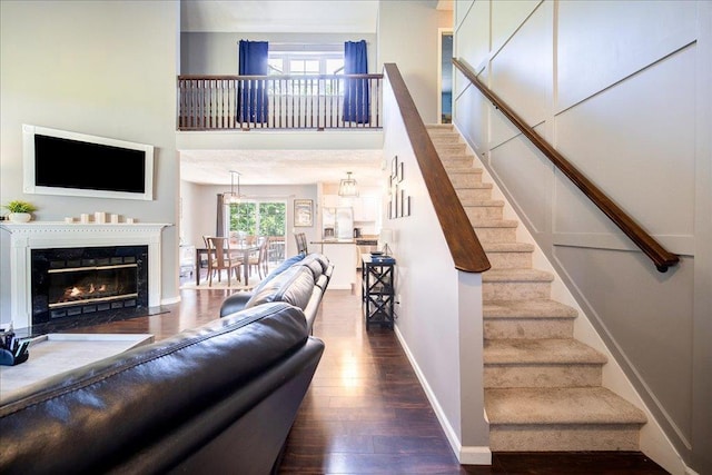 10 Lyford Ln, Poughkeepsie, NY 12601 - living room with wood finished floors, stairway, a towering ceiling, and a premium fireplace