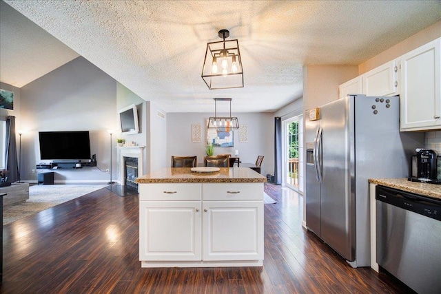 10 Lyford Ln, Poughkeepsie, NY 12601 - kitchen with stainless steel dishwasher, white cabinets, dark wood-style floors, a glass covered fireplace, and a center island