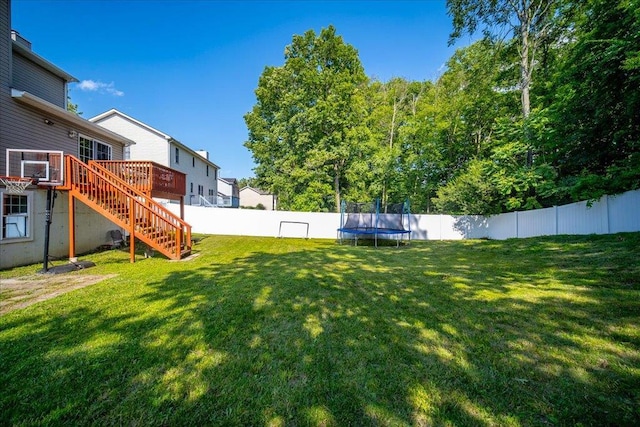 10 Lyford Ln, Poughkeepsie, NY 12601 - fenced backyard featuring a trampoline, stairs, and a deck