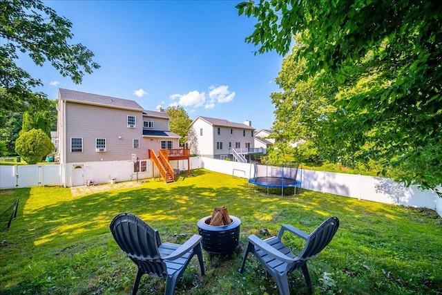 10 Lyford Ln, Poughkeepsie, NY 12601 - fenced backyard featuring a fire pit, stairway, a trampoline, and a deck
