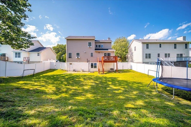 10 Lyford Ln, Poughkeepsie, NY 12601 - rear view of house featuring a trampoline, a fenced backyard, a wooden deck, stairway, and a chimney