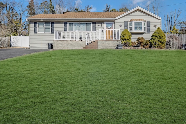 single story home with a front lawn, a porch, and fence