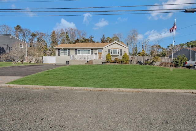 view of front of house with a front yard, fence, and covered porch