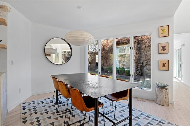 dining area with visible vents, baseboards, and light wood-style floors