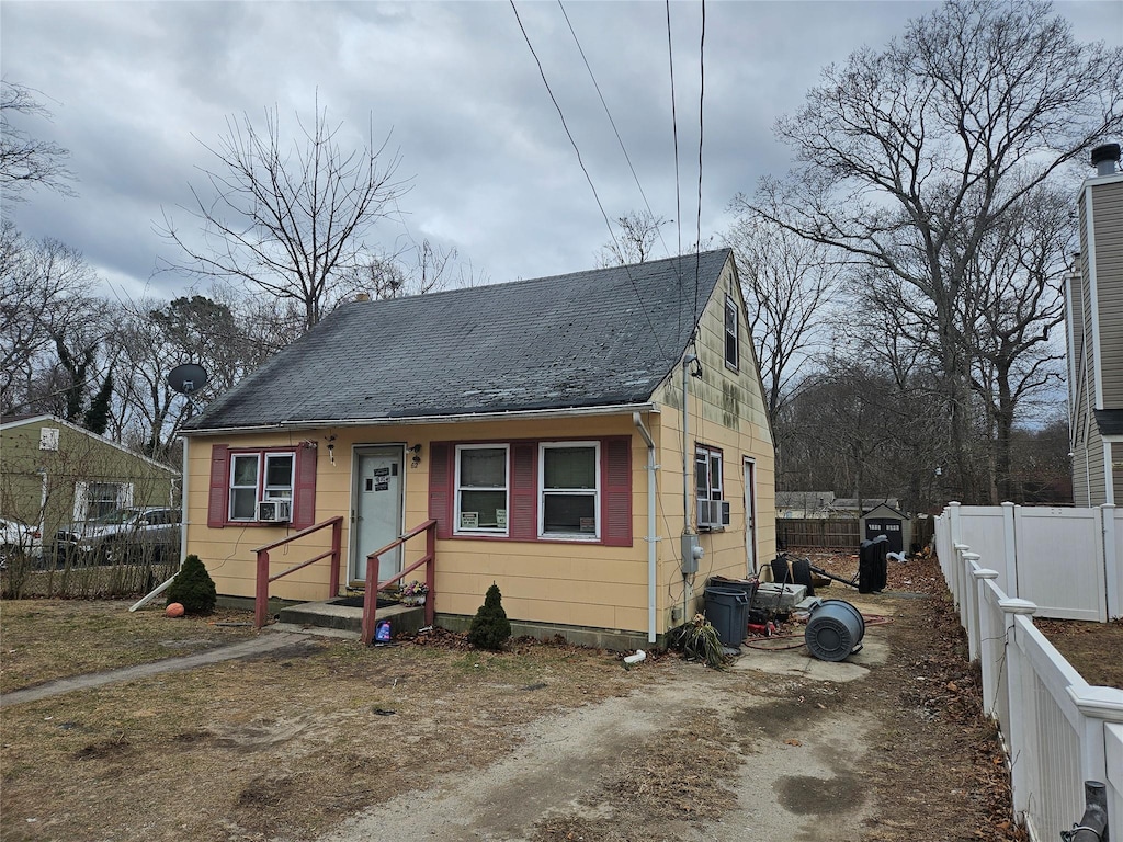 bungalow-style house with cooling unit and fence