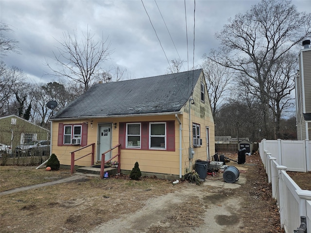 bungalow-style house with cooling unit and fence