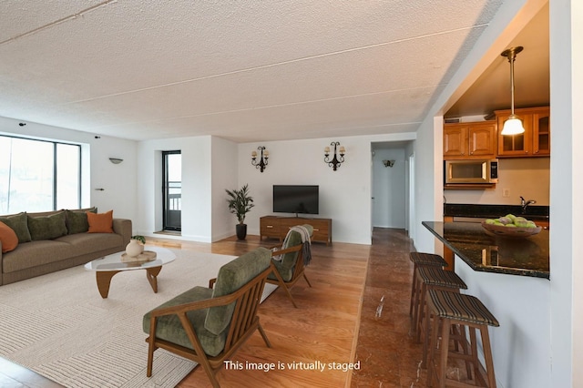living room featuring light wood-type flooring and a textured ceiling