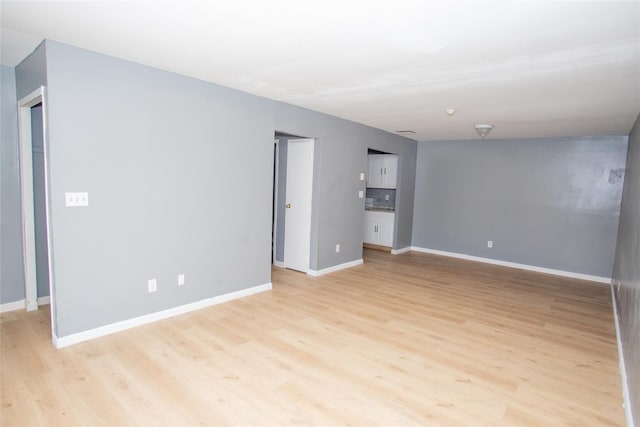 unfurnished living room featuring light wood-type flooring and baseboards