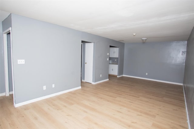 unfurnished room featuring baseboards and light wood finished floors