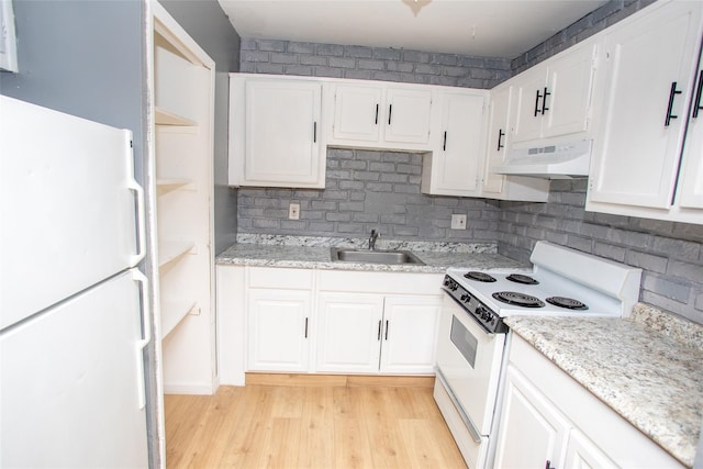 kitchen with under cabinet range hood, a sink, white appliances, white cabinets, and light wood finished floors