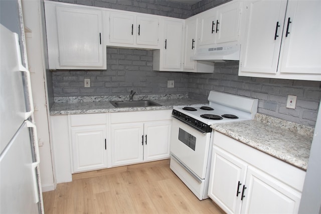 kitchen featuring under cabinet range hood, white cabinets, white appliances, and a sink