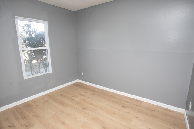 empty room featuring baseboards and light wood finished floors