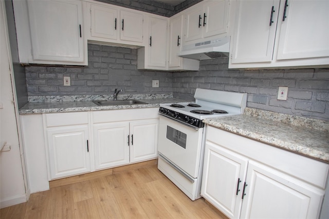 kitchen featuring electric range, light wood-style flooring, a sink, under cabinet range hood, and white cabinetry