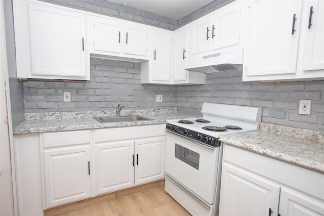 kitchen featuring electric stove, under cabinet range hood, a sink, white cabinetry, and decorative backsplash