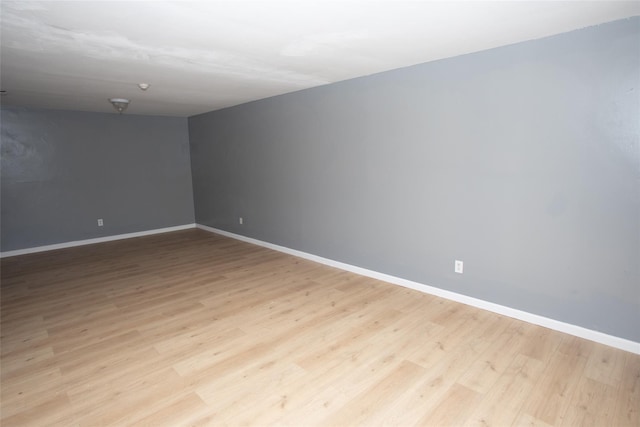 empty room with baseboards and light wood-type flooring