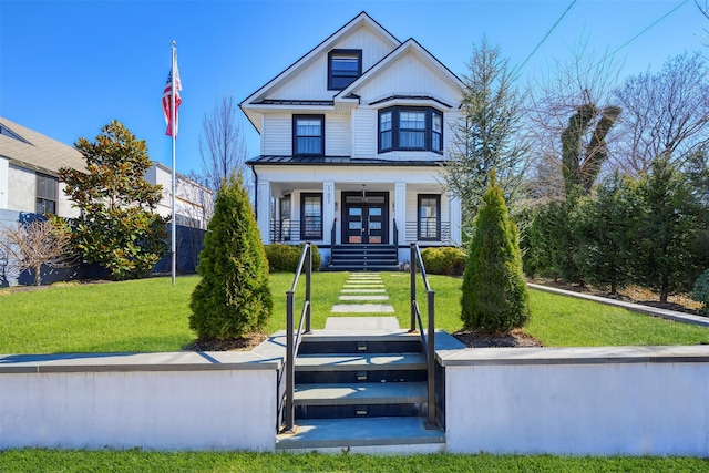 view of front of home with a front lawn, stairway, covered porch, metal roof, and a standing seam roof