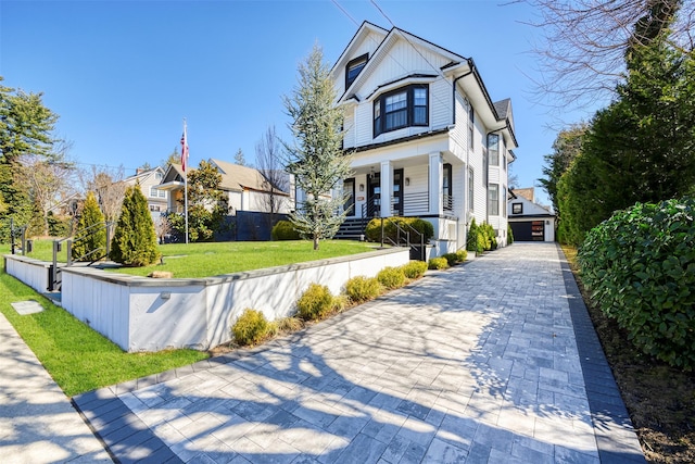 view of front of home featuring a front yard, a porch, a fenced front yard, board and batten siding, and a residential view