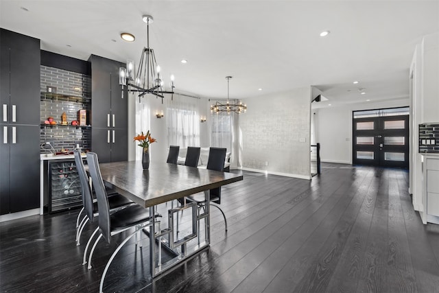 dining area with brick wall, a dry bar, recessed lighting, an inviting chandelier, and dark wood-style flooring