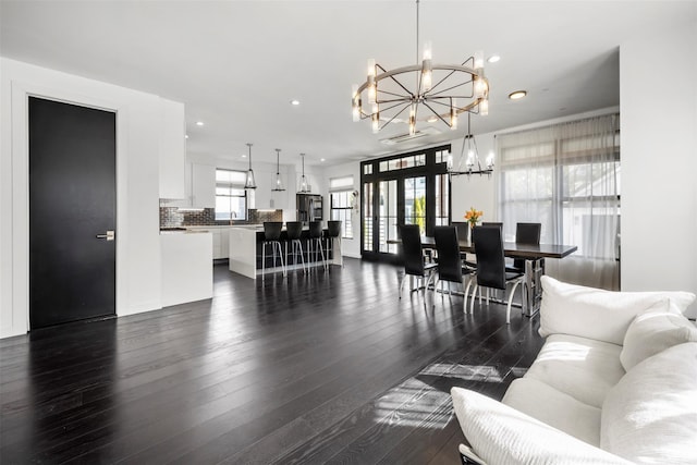 dining area with recessed lighting, an inviting chandelier, and dark wood-style flooring