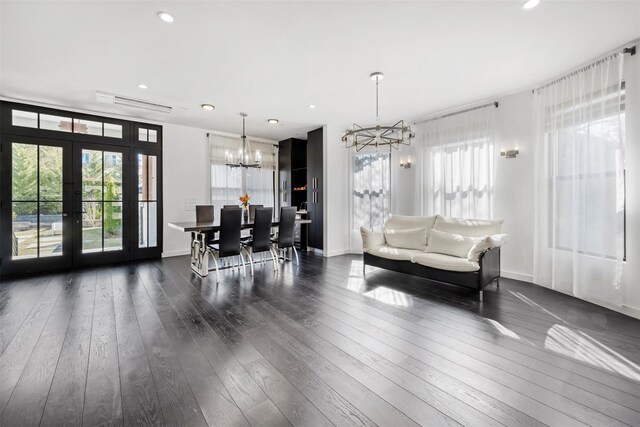 living area featuring a chandelier, recessed lighting, baseboards, and hardwood / wood-style flooring