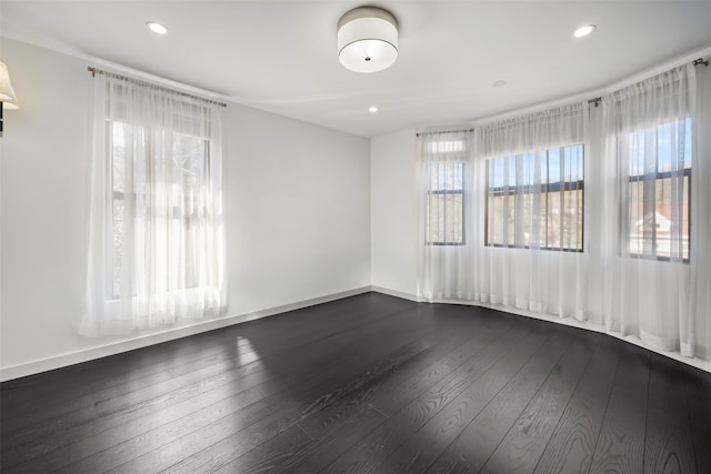 empty room featuring dark wood-style floors, recessed lighting, and baseboards