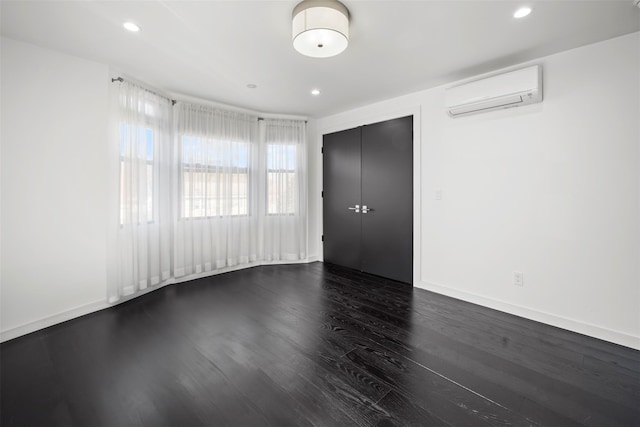 interior space featuring dark wood-type flooring, recessed lighting, baseboards, and a wall mounted air conditioner