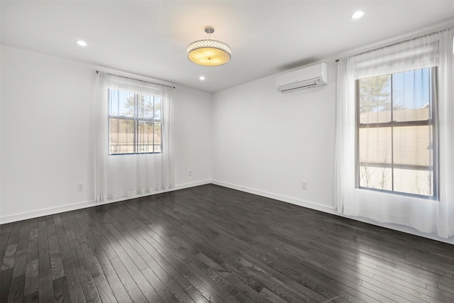 spare room with recessed lighting, baseboards, an AC wall unit, and dark wood-style floors