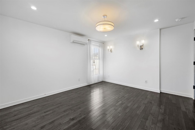 empty room with recessed lighting, baseboards, an AC wall unit, and dark wood finished floors