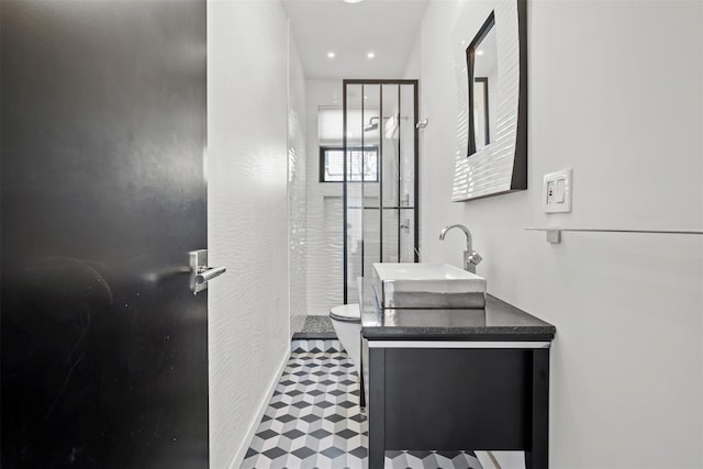 full bathroom featuring tile patterned floors, toilet, a stall shower, baseboards, and vanity