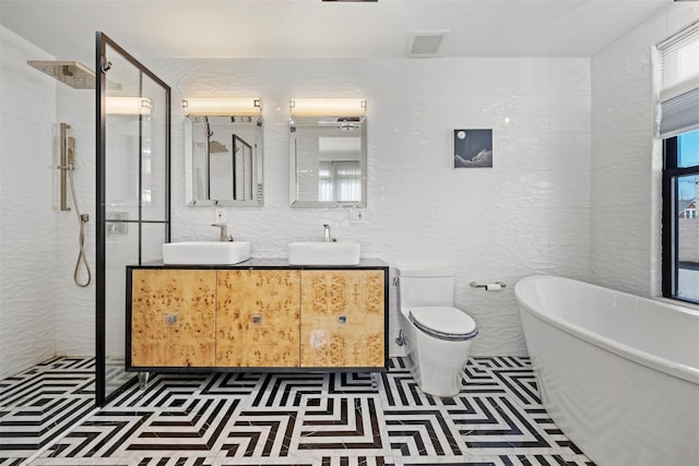 full bathroom featuring a freestanding bath, tile walls, a shower stall, and a sink