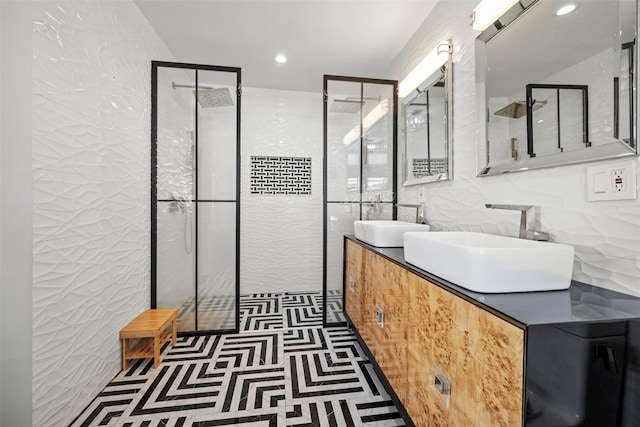 bathroom with a sink, tile walls, double vanity, and a walk in shower