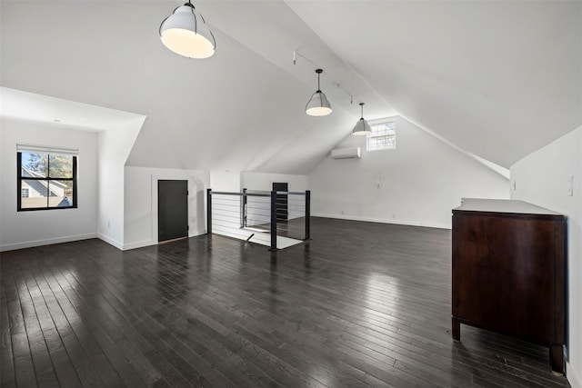 bonus room with baseboards, dark wood-type flooring, a wall unit AC, and vaulted ceiling