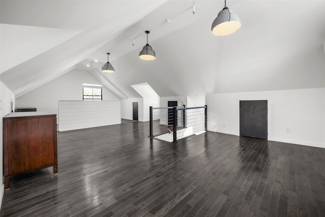 additional living space featuring dark wood finished floors and vaulted ceiling