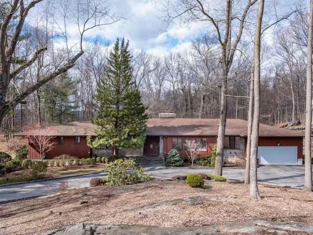 single story home with aphalt driveway and a garage