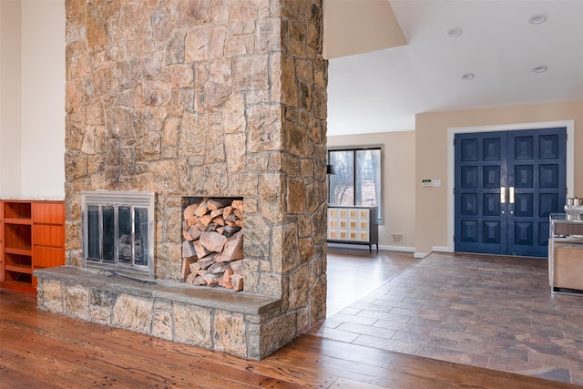 entrance foyer featuring wood finished floors, a fireplace, baseboards, and visible vents