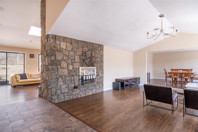 living room featuring vaulted ceiling with skylight, a fireplace, and wood finished floors