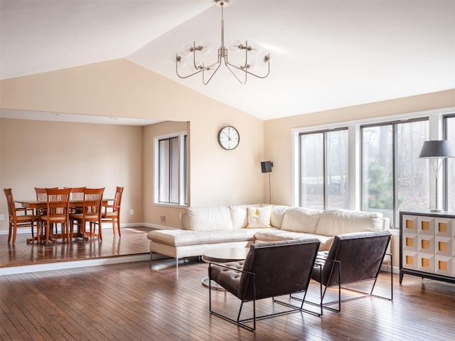 living area featuring baseboards, an inviting chandelier, hardwood / wood-style floors, and vaulted ceiling