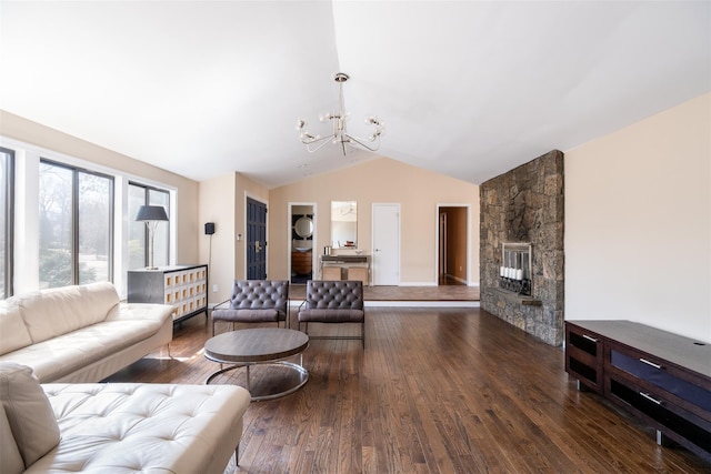 living room with dark wood-style floors, a notable chandelier, a fireplace, and vaulted ceiling