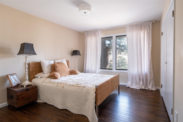 bedroom with baseboards and dark wood finished floors