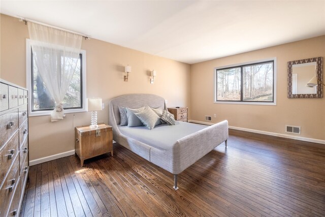 bedroom featuring visible vents, multiple windows, baseboards, and dark wood-style floors